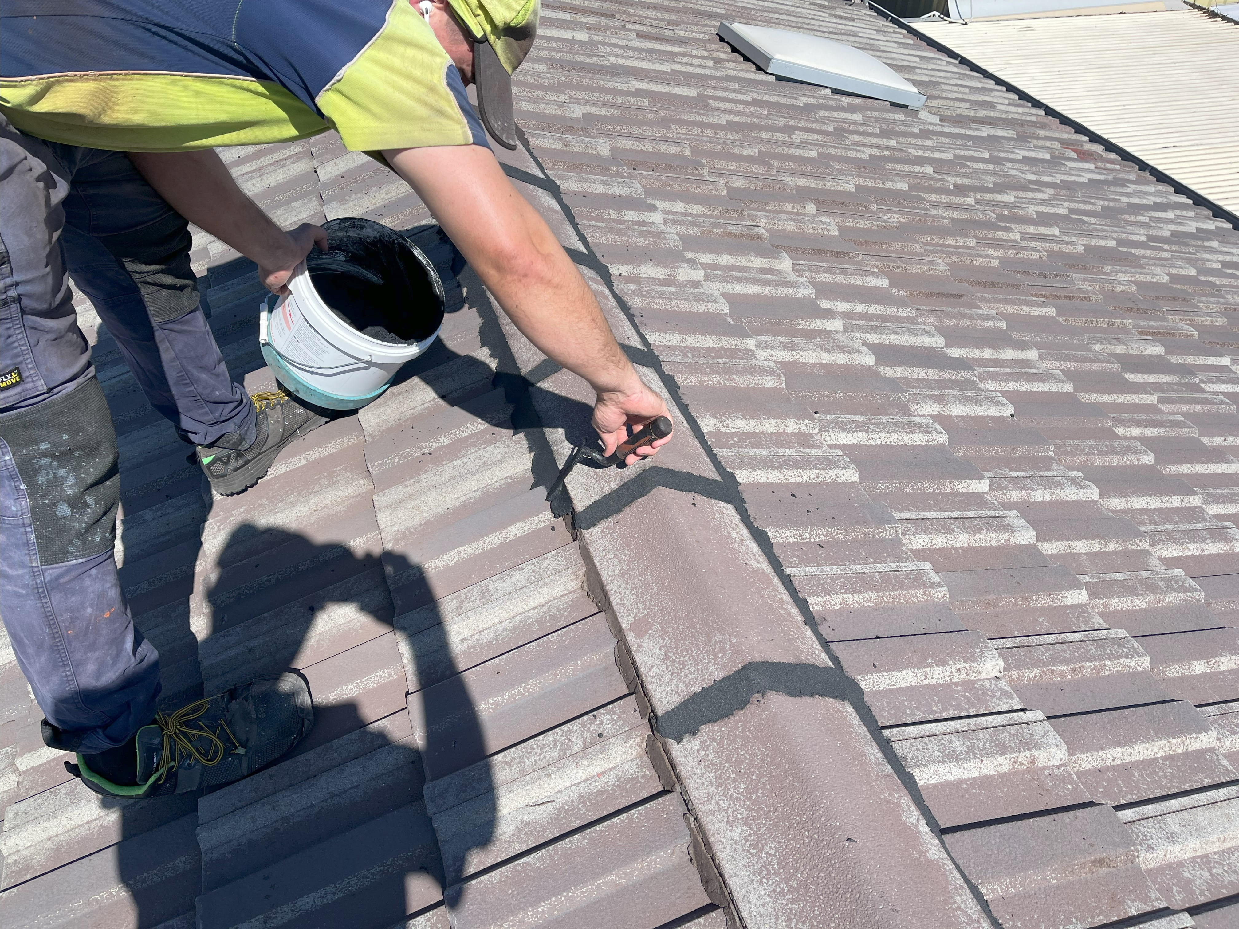 a photo of ridge capping being repointed by roof restorers perth