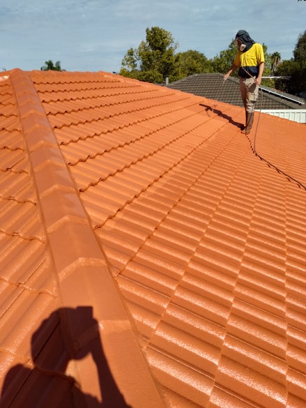 a photo of a roof being sprayed with an airless sprayer