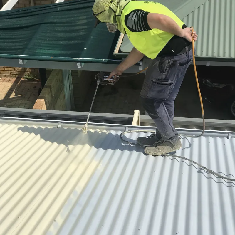 Spraying a top coat onto a primed and sealed Perth tile roof