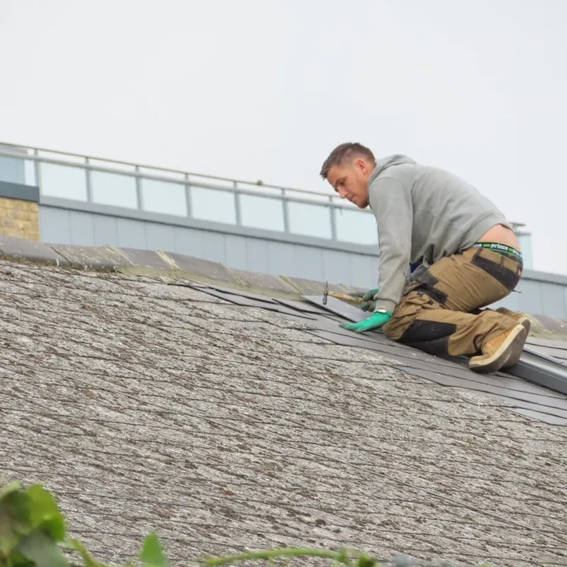 A roofer working through the stages of a roof restoration on a Perth home