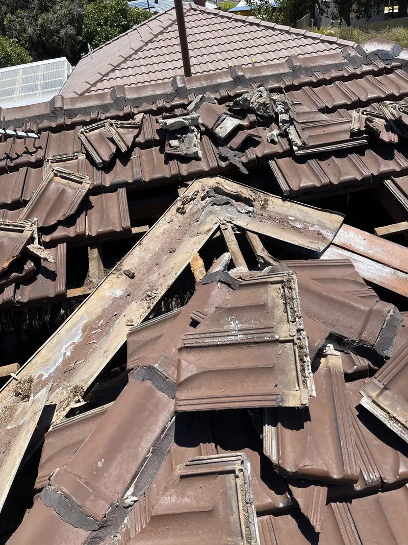 A roofer inspecting roof damage
